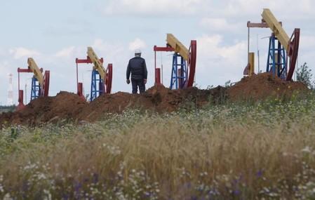 FILE PHOTO: A worker stands in front of pump jacks at the Ashalchinskoye oil field owned by Russia's oil producer Tatneft near Almetyevsk