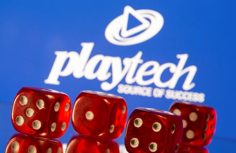 Gambling cubes are seen in front of displayed Playtech logo in this illustration taken