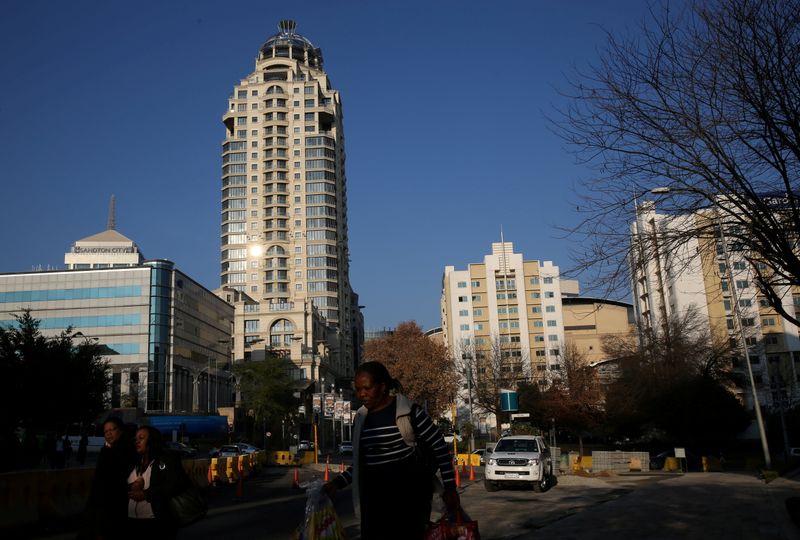 FILE PHOTO: Michelangelo towers are seen as pedestrians make their way to work past road construction site in Sandton outside Johannesburg