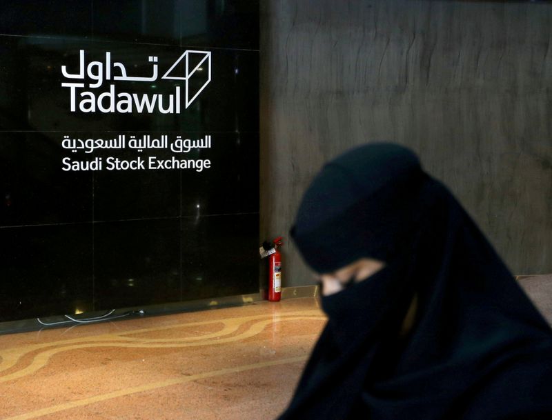 FILE PHOTO: Saudi woman walks at the Saudi stock market (Tadawul), in Riyadh