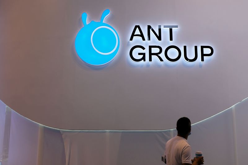 FILE PHOTO: Man walks past an Ant Group logo in Shanghai