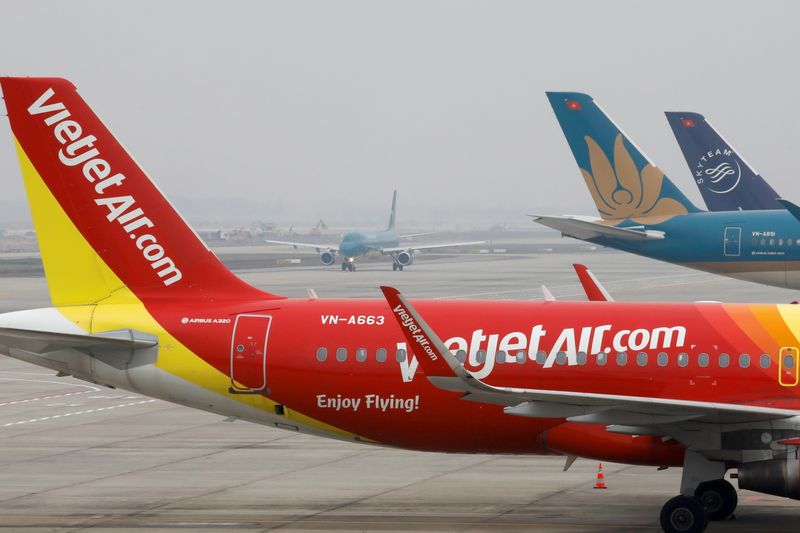 Aircraft of the national flag carrier Vietnam Airlines taxis between a Vietjet aircraft at Noi Bai airport in Hanoi