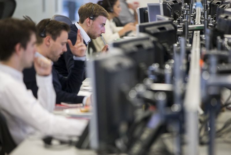 Dealers work on the IG Group trading floor in London, Britain