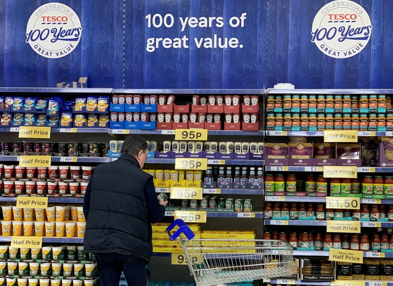 FILE PHOTO: A man looks at products on a shelf inside a Tesco Extra superstore near Manchester