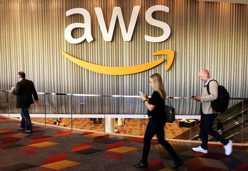 FILE PHOTO: Attendees at Amazon.com Inc annual cloud computing conference walk past the Amazon Web Services logo in Las Vegas