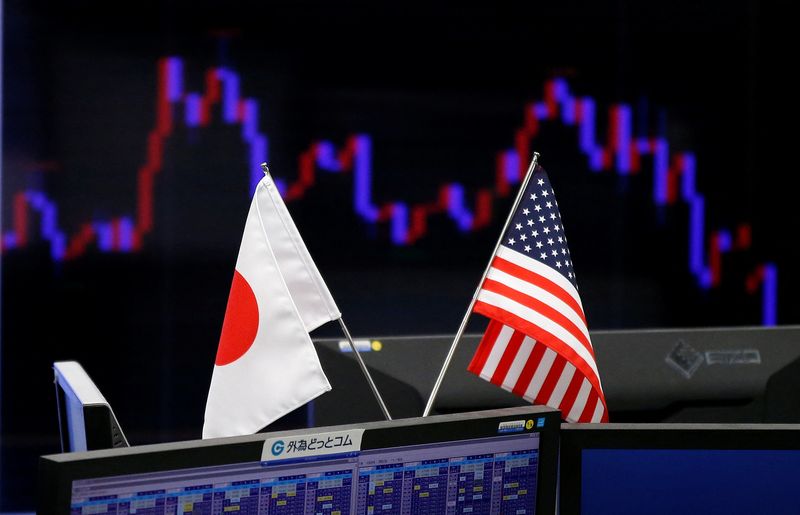 FILE PHOTO: National flags of Japan and the U.S. are seen in front of a monitor showing a graph of the Japanese yen's exchange rate against the U.S. dollar at a foreign exchange trading company in Tokyo