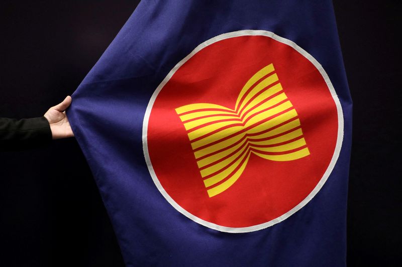 FILE PHOTO: A worker adjusts an ASEAN flag at a meeting hall in Kuala Lumpur