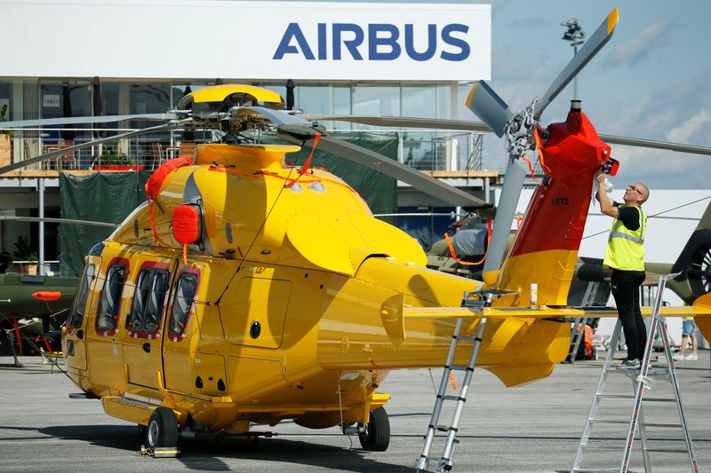 A worker cleans up a H175 Airbus helicopter on the static display, two days before the opening of the 53rd International Paris Air Show at Le Bourget Airport near Paris