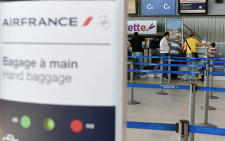Passengers stand at an Air France desk in Nice Cote D'Azur International airport on the first day of a strike by Air France stewards, in Nice