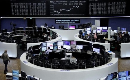 FILE PHOTO: Traders work in front of the German share price index, DAX board, at the stock exchange in Frankfurt