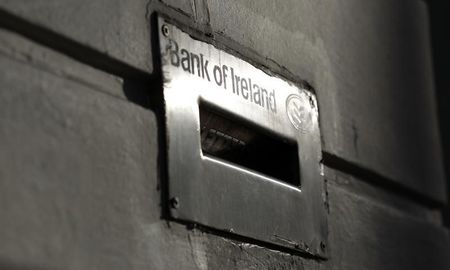 Sunlight is reflected off a deposit box on the exterior of a Bank Of Ireland branch in Belfast