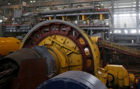 FILE PHOTO: Employees walk near rotating crusher equipment inside a gold procession plant at the Olimpiada gold operation in Krasnoyarsk region