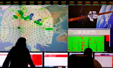 FILE PHOTO: Staff at satellite communications company Inmarsat work in front of a screen showing subscribers using their service throughout the world, at their headquarters in London