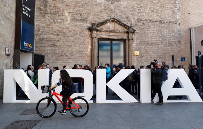 FILE PHOTO: A cyclist rides past a Nokia logo during the Mobile World Congress in Barcelona