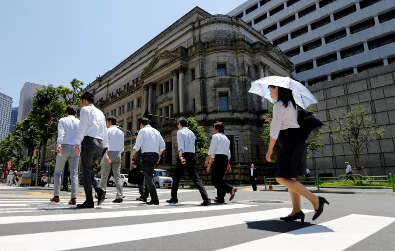 People walk past the Bank of Japan building in Tokyo