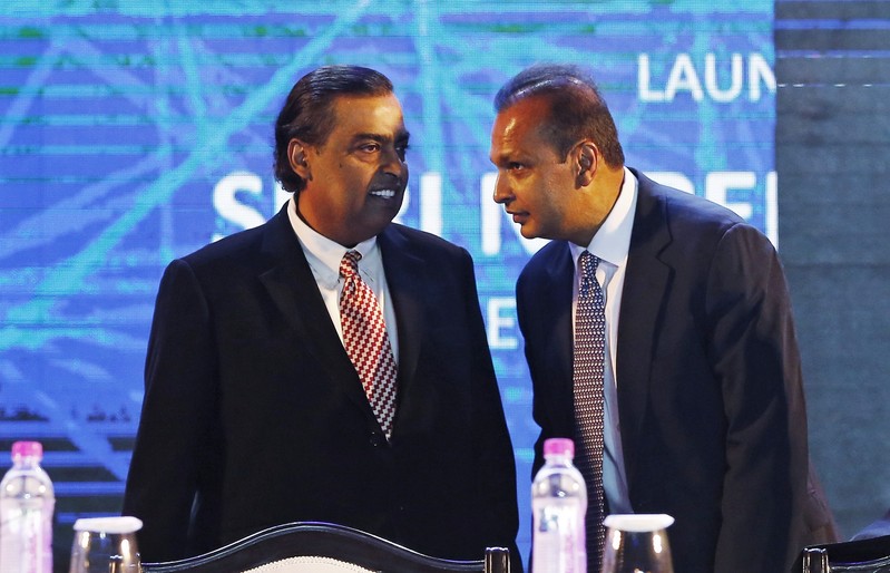 FILE PHOTO: Anil Ambani talks to his brother Mukesh during the launch of Digital India Week in New Delhi