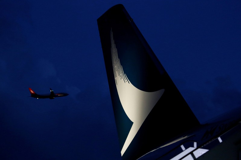 FILE PHOTO: Plane flies behind a new Cathay Pacific Airways Airbus A350 after being received by the airline at Hong Kong