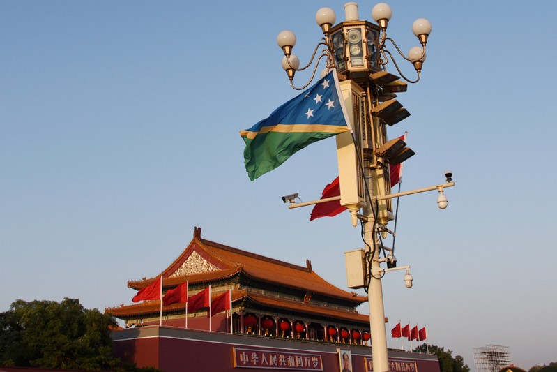 FILE PHOTO: The national flags of Solomon Islands and China flutter at Tiananmen Square in Beijing