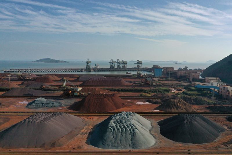 Piles of imported iron ore are seen at a port in Zhoushan, Zhejiang