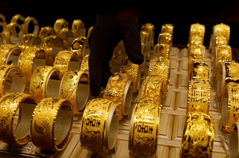FILE PHOTO: A salesperson arranges 24K gold bracelets for Chinese weddings at Chow Tai Fook Jewellery store in Hong Kong
