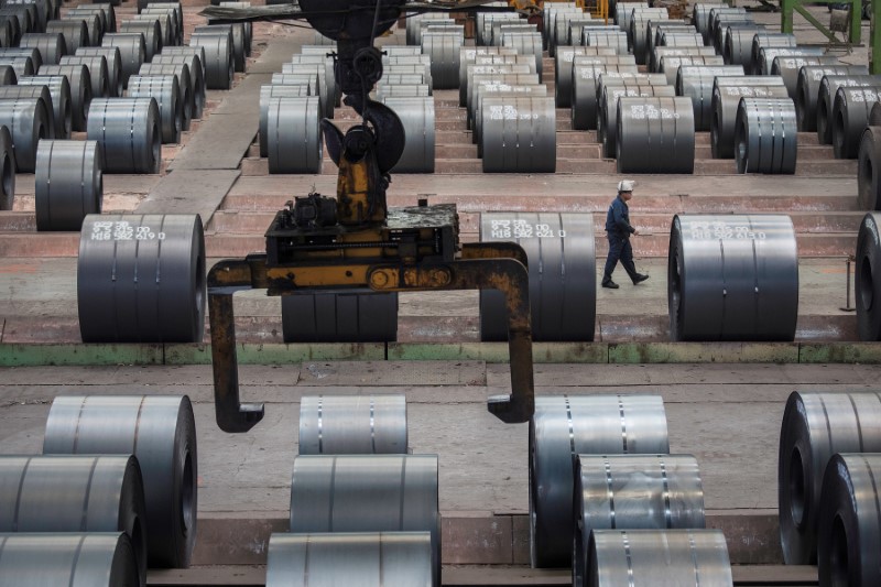FOTO DE ARCHIVO. Un trabajador camina junto a rollos de acero en la planta de Chongqing Iron and Steel en Changshou, Chongqing, China