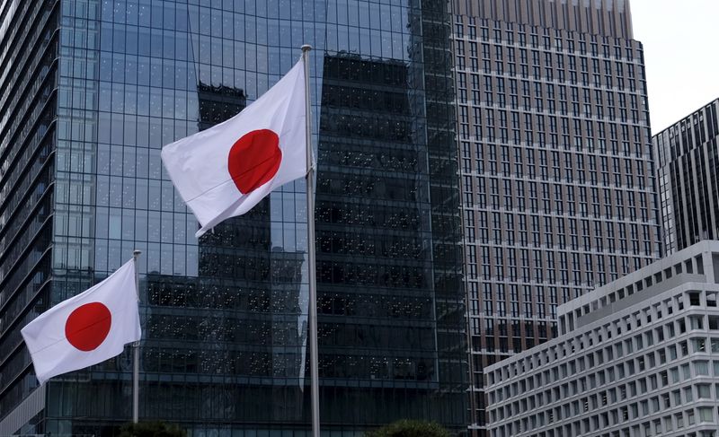 FILE PHOTO: Japanese national flags flutter in front of buildings at Tokyo's business district