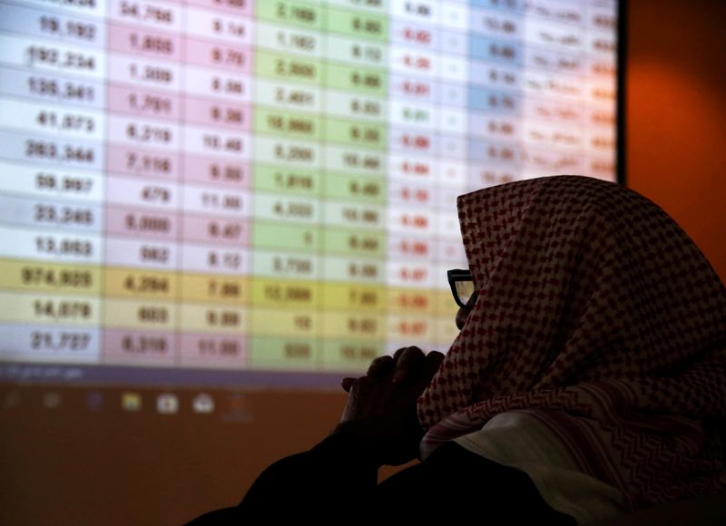 FILE PHOTO: A Saudi trader monitors stocks at the Saudi stock market in Riyadh