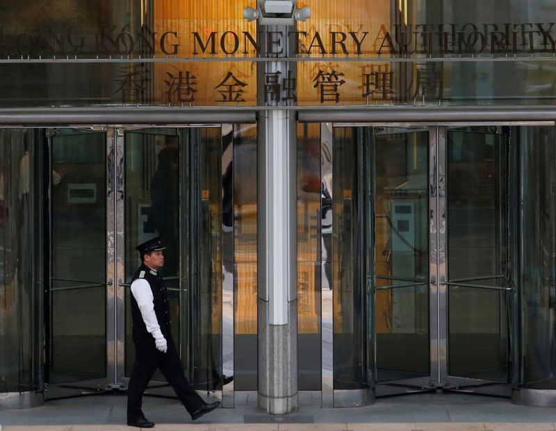 FOTO DE ARCHIVO: Un asistente camina frente a la entrada de la Autoridad Monetaria de Hong Kong en Hong Kong