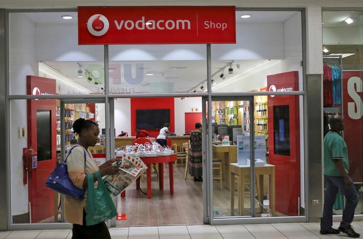 FILE PHOTO: A shopper walks past a Vodacom shop in Johannesburg