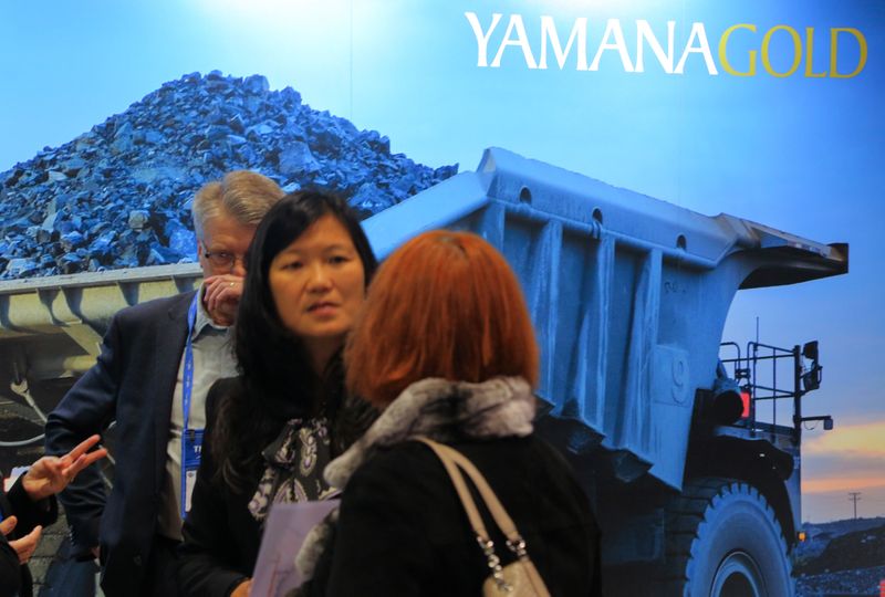 FILE PHOTO: Visitors to the Yamana Gold mining company booth speak with representatives during the PDAC convention in Toronto
