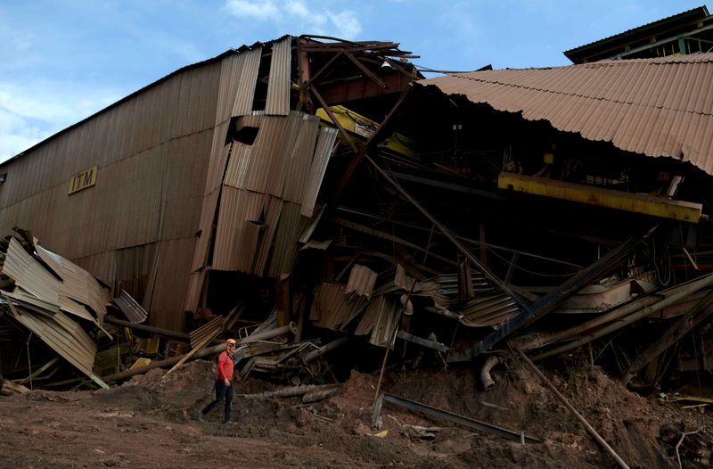 FILE PHOTO: A member of a rescue team walks next to a collapsed tailings dam owned by Brazilian mining company Vale in Brumadinho
