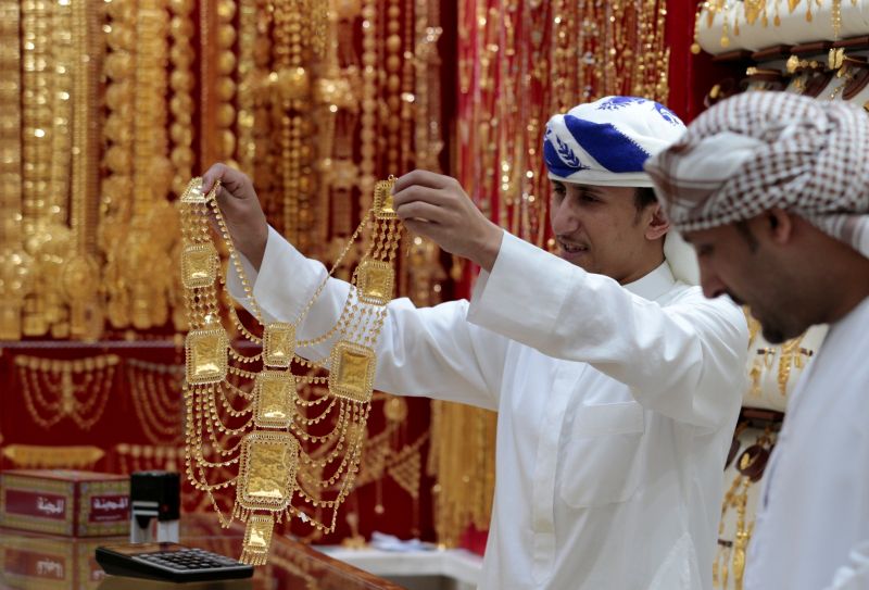 FILE PHOTO: An employee shows a customer gold jewellery in a shop at the Gold Souq in Dubai