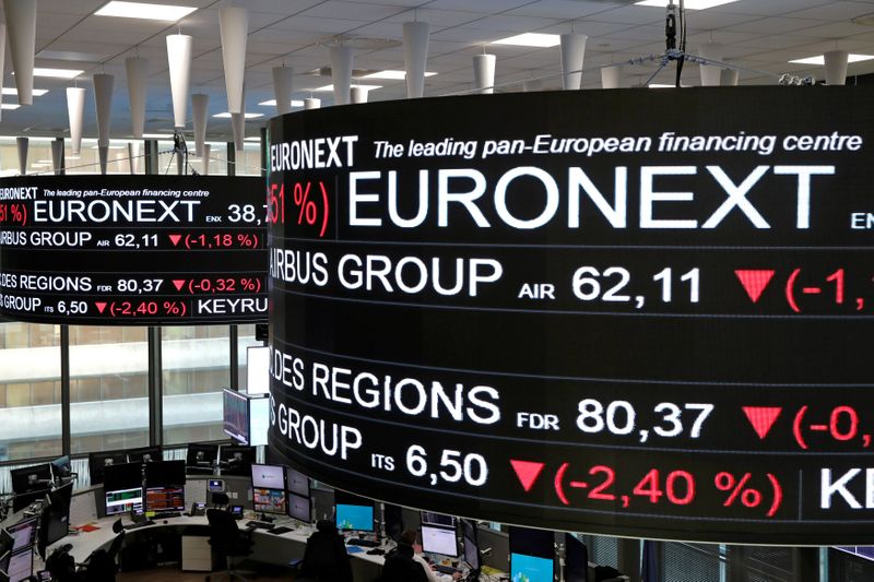 FILE PHOTO: Company stock price information are displayed on screens as they hang above the Paris stock exchange, operated by Euronext NV, in La Defense business district in Paris