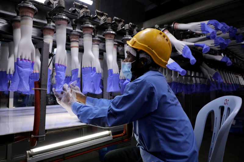FILE PHOTO: A worker inspects newly-made gloves at Top Glove factory in Shah Alam