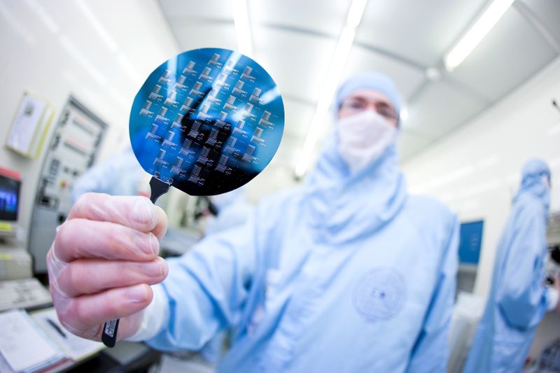 FILE PHOTO: A scientist presents a silicon wafer during a media presentation in one of the low particle pollution nanofabrication clean rooms of the Swiss Federal Institute of Technology