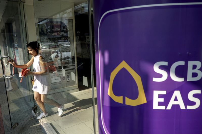 FILE PHOTO: A woman walks out from a Siam Commercial Bank branch in Bangkok