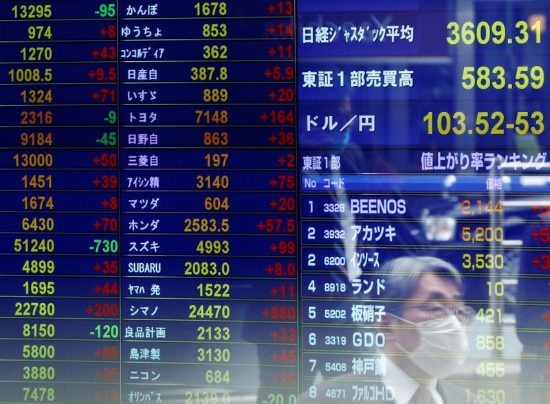 Un uomo riflesso su uno schermo presso il distretto finanziario di Tokyo