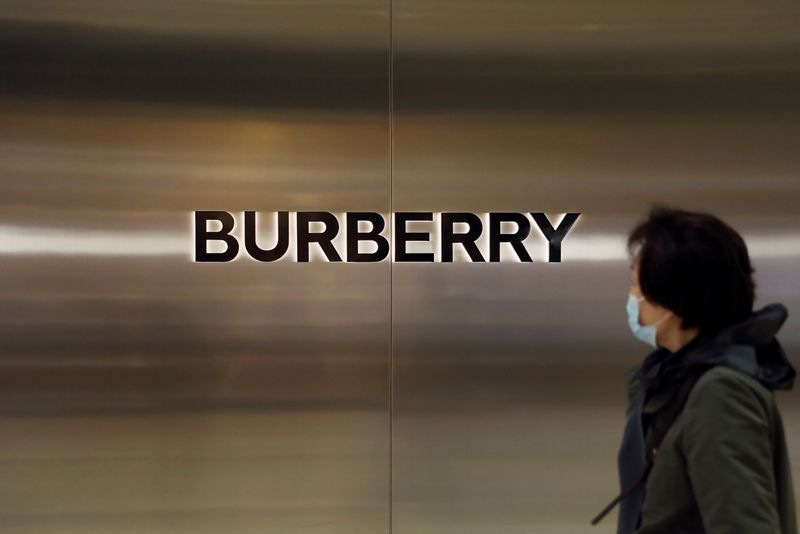 Woman walks past a Burberry store in Beijing