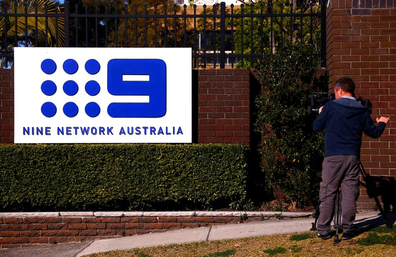 FILE PHOTO: A television cameraman films the logo of Nine Entertainment Co Holdings Ltd on display outside its Sydney headquarters
