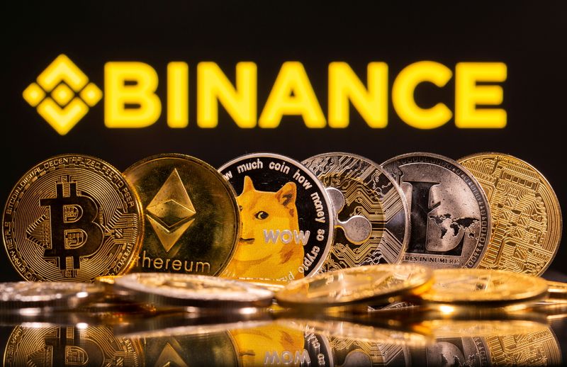 FILE PHOTO: Representations of cryptocurrencies Bitcoin, Ethereum, DogeCoin, Ripple, and Litecoin are seen in front of a displayed Binance logo