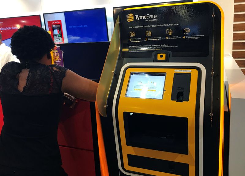 A woman stands next to a TymeBank client onboarding kiosk in Johannesburg