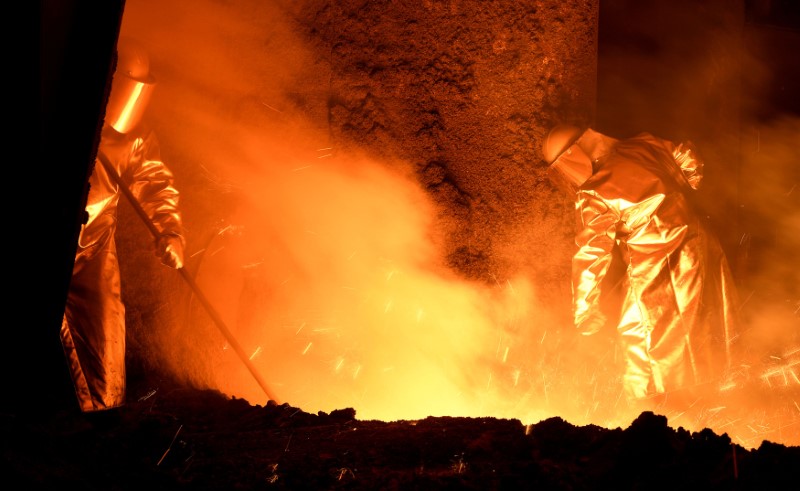 FILE PHOTO: Steelworkers stand at a furnace at the plant of German steel company Salzgitter AG in Salzgitter
