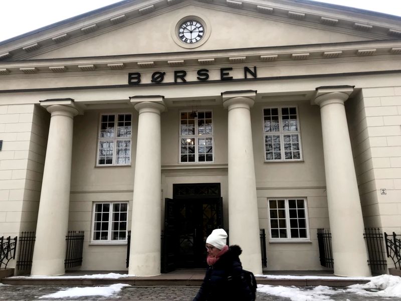 FILE PHOTO: A woman walks past the Oslo Stock Exchange building in Oslo