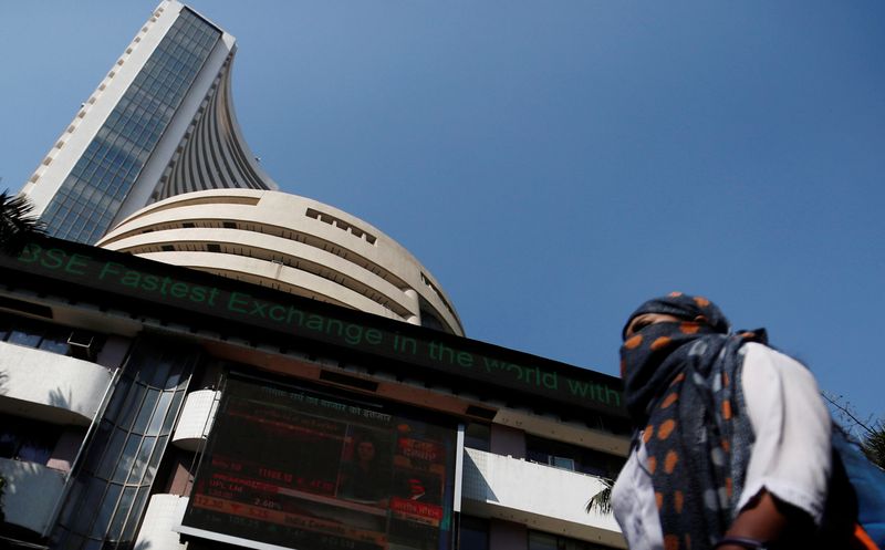 FILE PHOTO: A woman walks past the Bombay Stock Exchange building in Mumbai