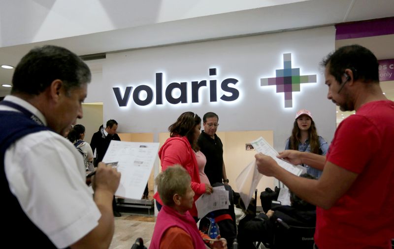 Passenger talks to an airline employee of the Mexican low-cost air carrier Volaris at Benito Juarez International Airport in Mexico City