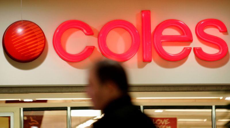 FILE PHOTO: Shopper stands in front of a Coles supermarket sign in Sydney