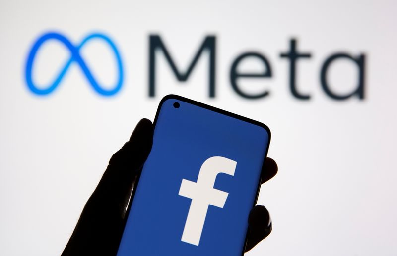 Un telefono cellulare con il logo di Facebook è visibile davanti al nuovo logo dopo il rebranding in Meta, in questa illustrazione scattata il 28 ottobre 2021.
