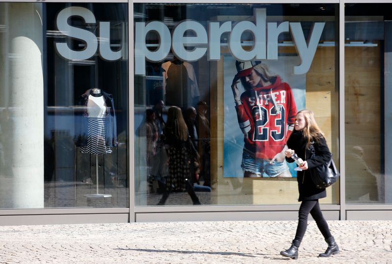 A woman walks past a Superdry fashion store in Berlin