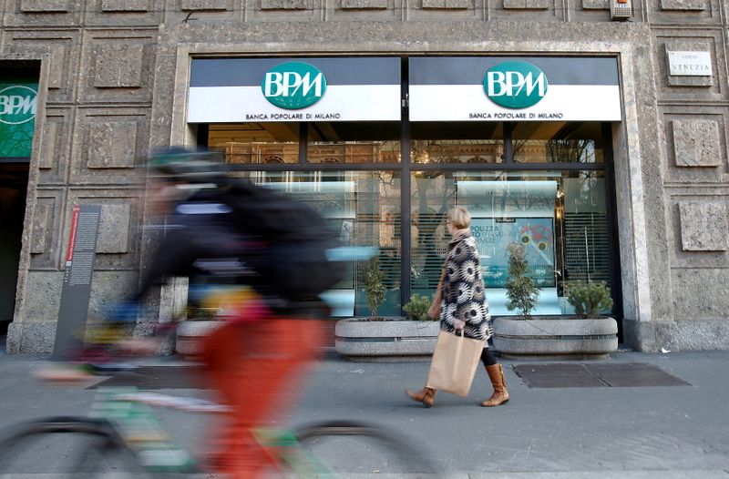 FILE PHOTO: A woman walks in front of the Banca Popolare di Milano (BPM) bank in downtown Milan