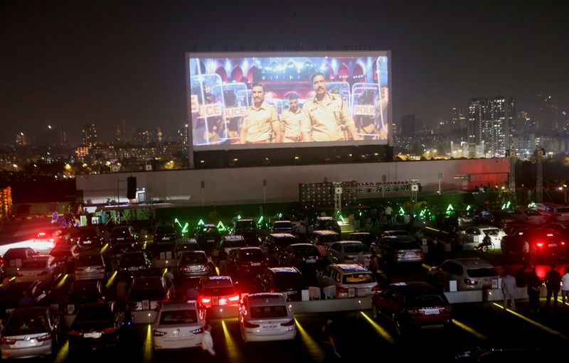 People watch a movie from their cars during a premiere screening at India's first open air rooftop drive-in cinema in Mumbai